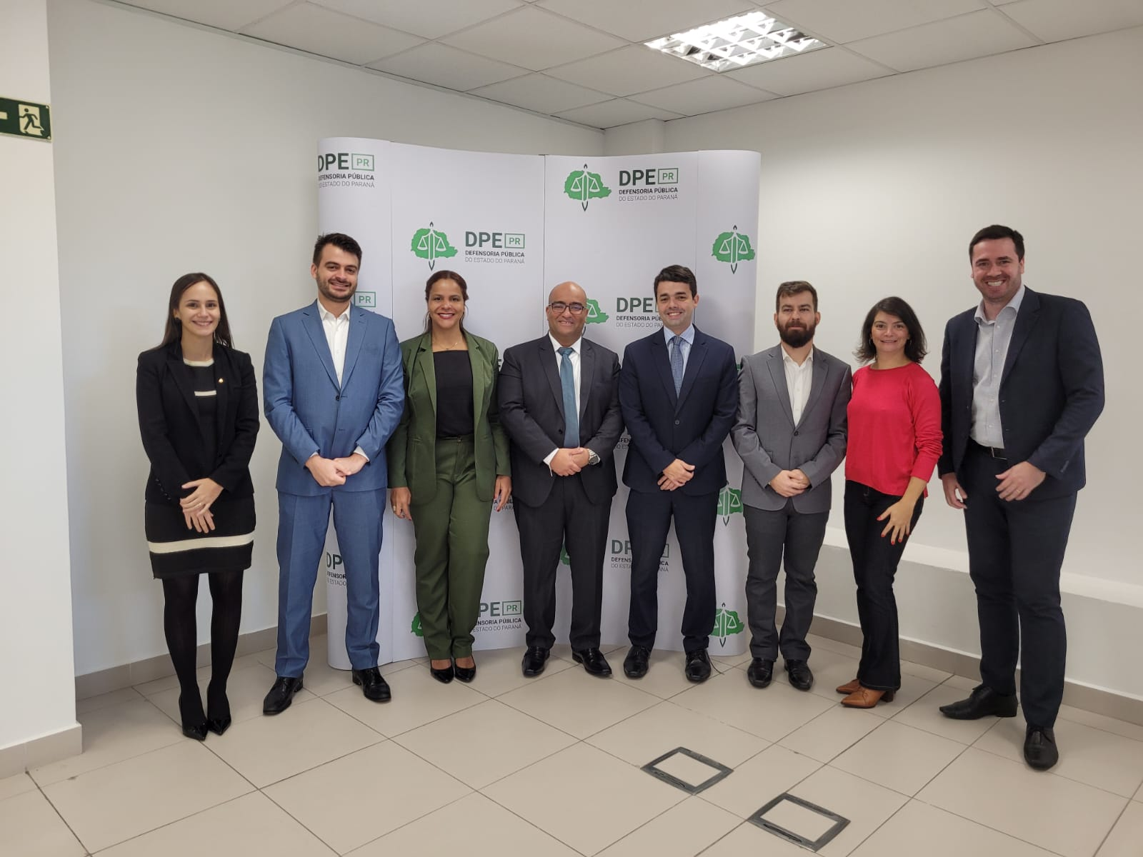 Imagem mostra oito pessoas sorrindo para a câmera