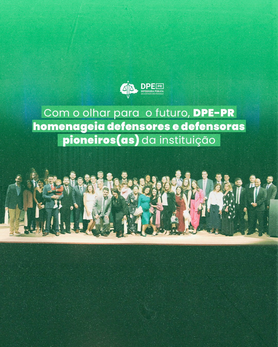 Imagem que mostra todos os defensores e defensoras presentes na cerimônia no palco do auditório. Acima da imagem está escrito o título da matéria.
