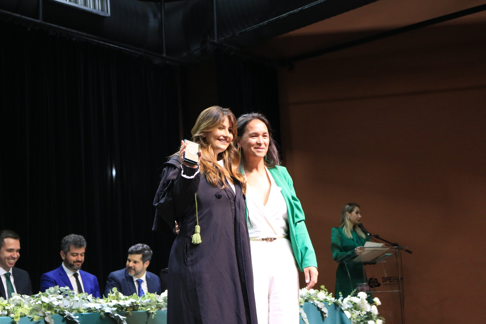 Imagem que mostra a defensora pública Bruna Moncavo recém empossada, posando para fotos ao lado da ouvidora da DPE-PR, Karollyne Nascimento, em cerimônia realizada nesta quinta-feira (18), em Curitiba.
