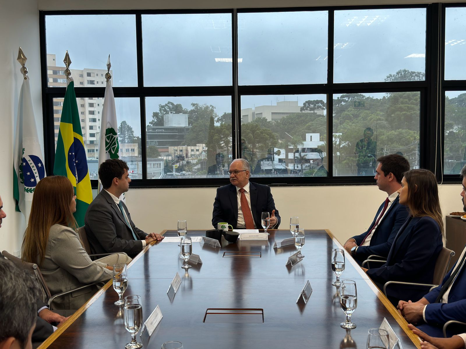 Imagem com a foto do Ministro Fachin sentado à mesa com personalidades representantes das catergorias da Defensoria.