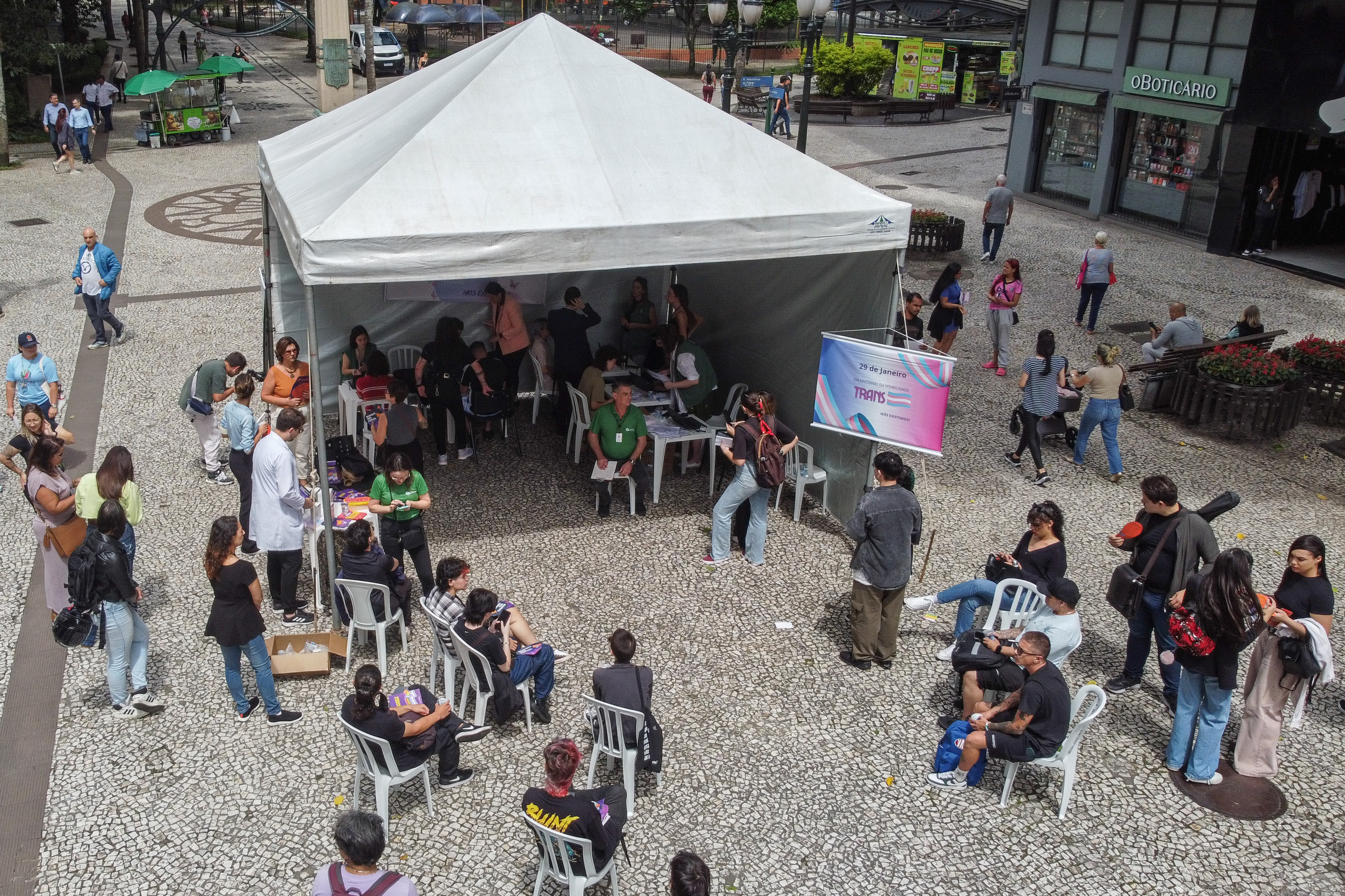 Imagem horizontal colorida feita de drone em que aparece a tenda montada na Boca Maldita e as pessoas aguardando o atendimento para o Mutirão da DPE-PR.