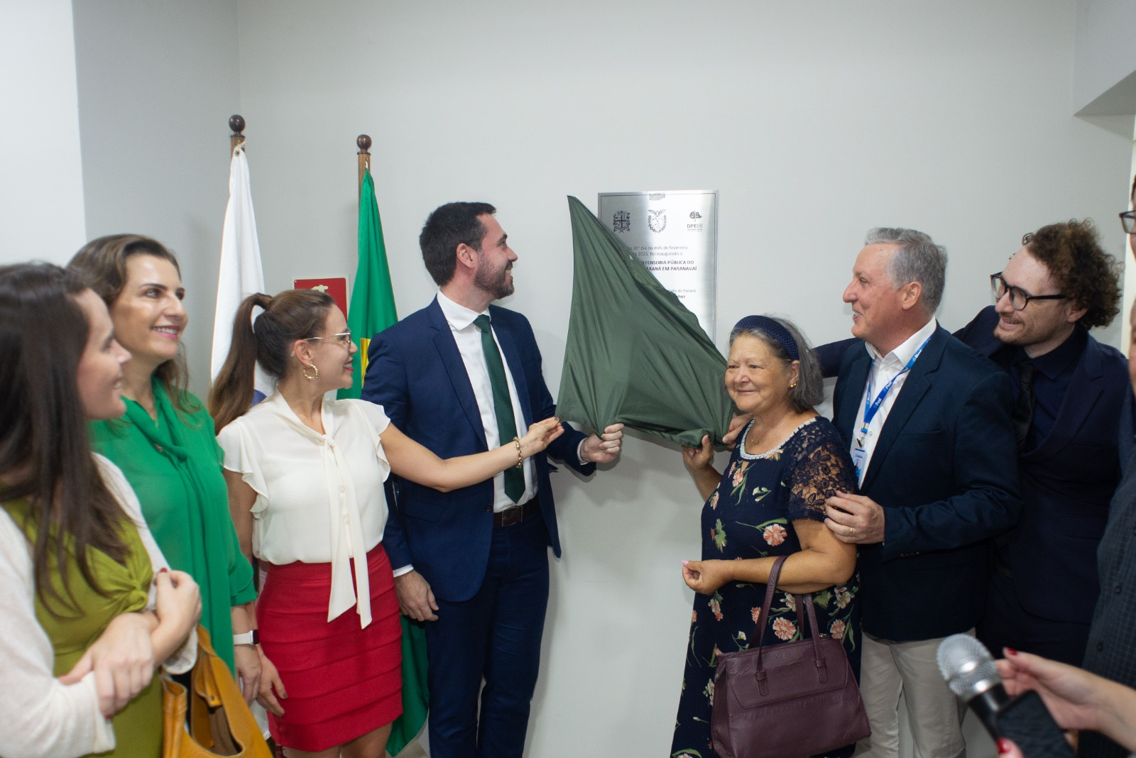 Momento do descerramento da placa de inauguração, com defensores públicos e autoridades reunidos ao redor, aplaudindo o marco da nova sede.