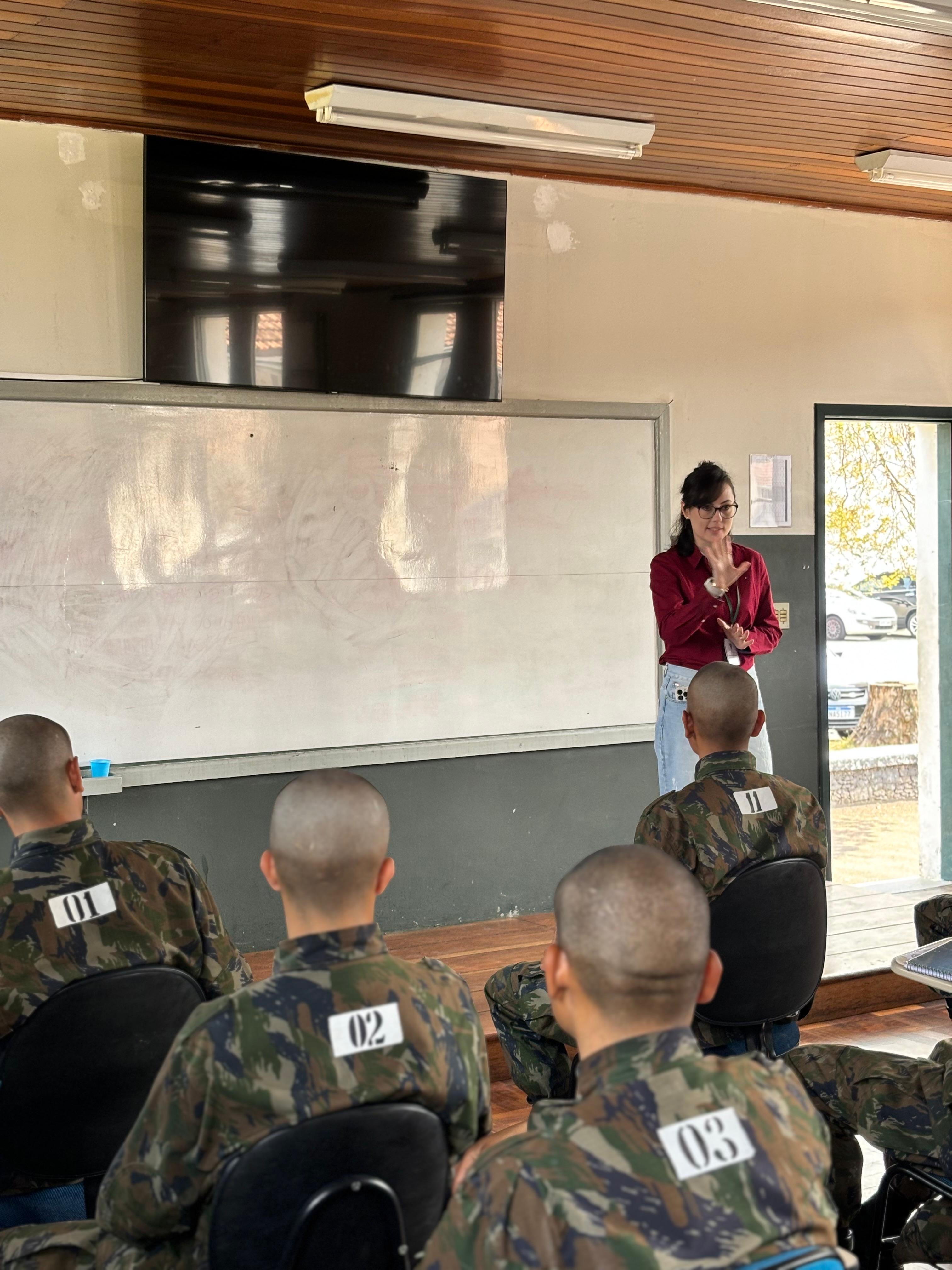 Imagem colorida em que se vê Jéssica fazendo palestra sobre Direitos Humanos para Policiais. 