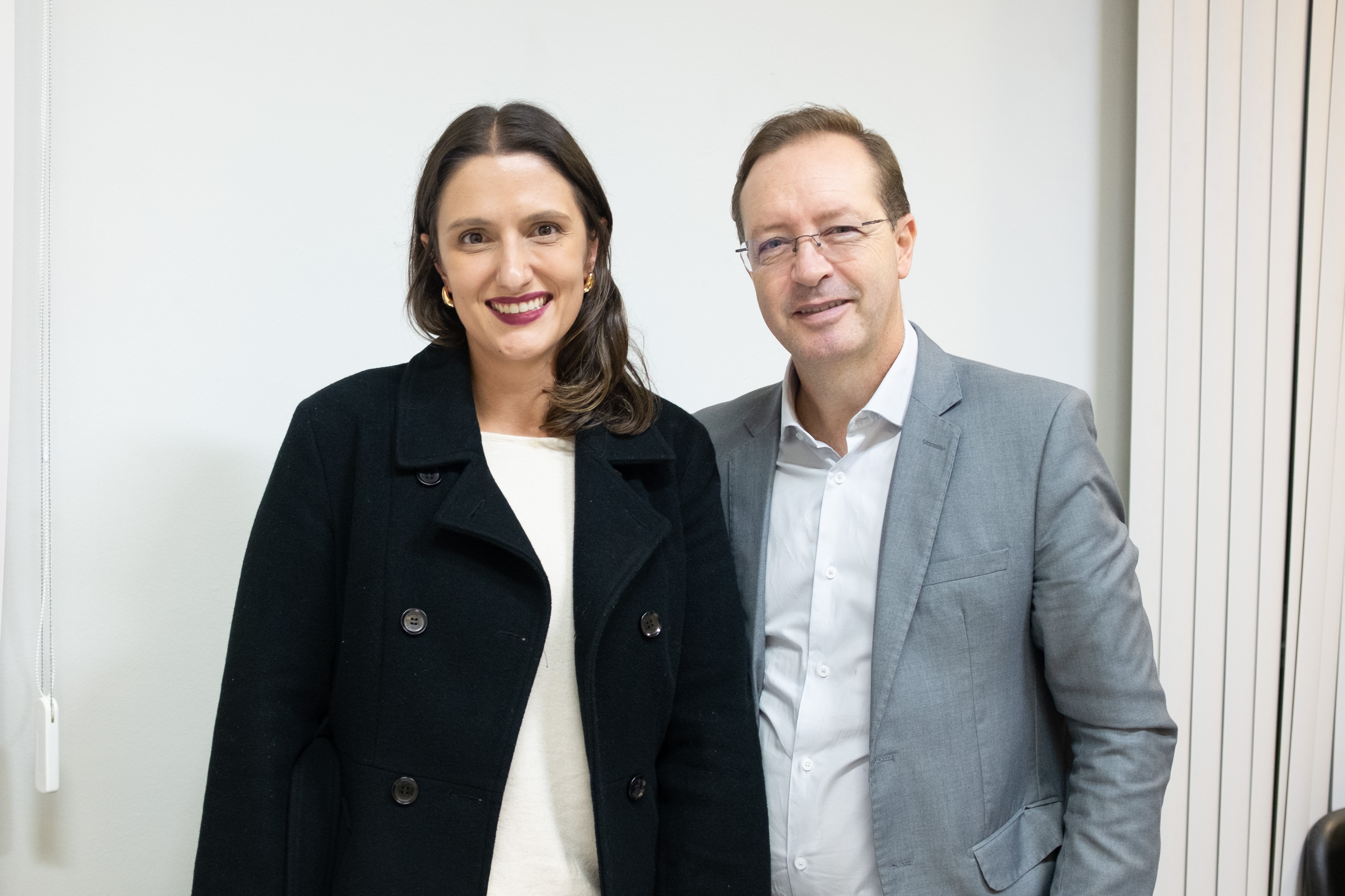 Imagem colorida horizontal em que se vê Defensora Pública Mariana Mantovani e o Promotor de Justiça Régis Sartori. 