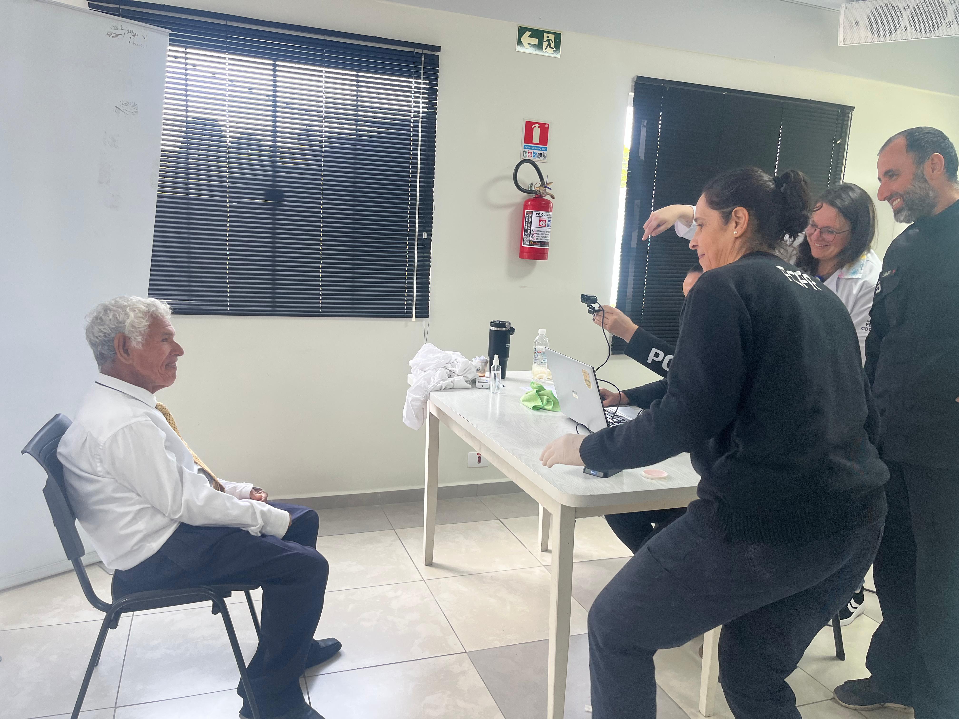 Equipe do Institito de Identificação do Paraná realiza fotografia para carteira de identidade de um homem idoso residente do Perqueno Cotolengo.