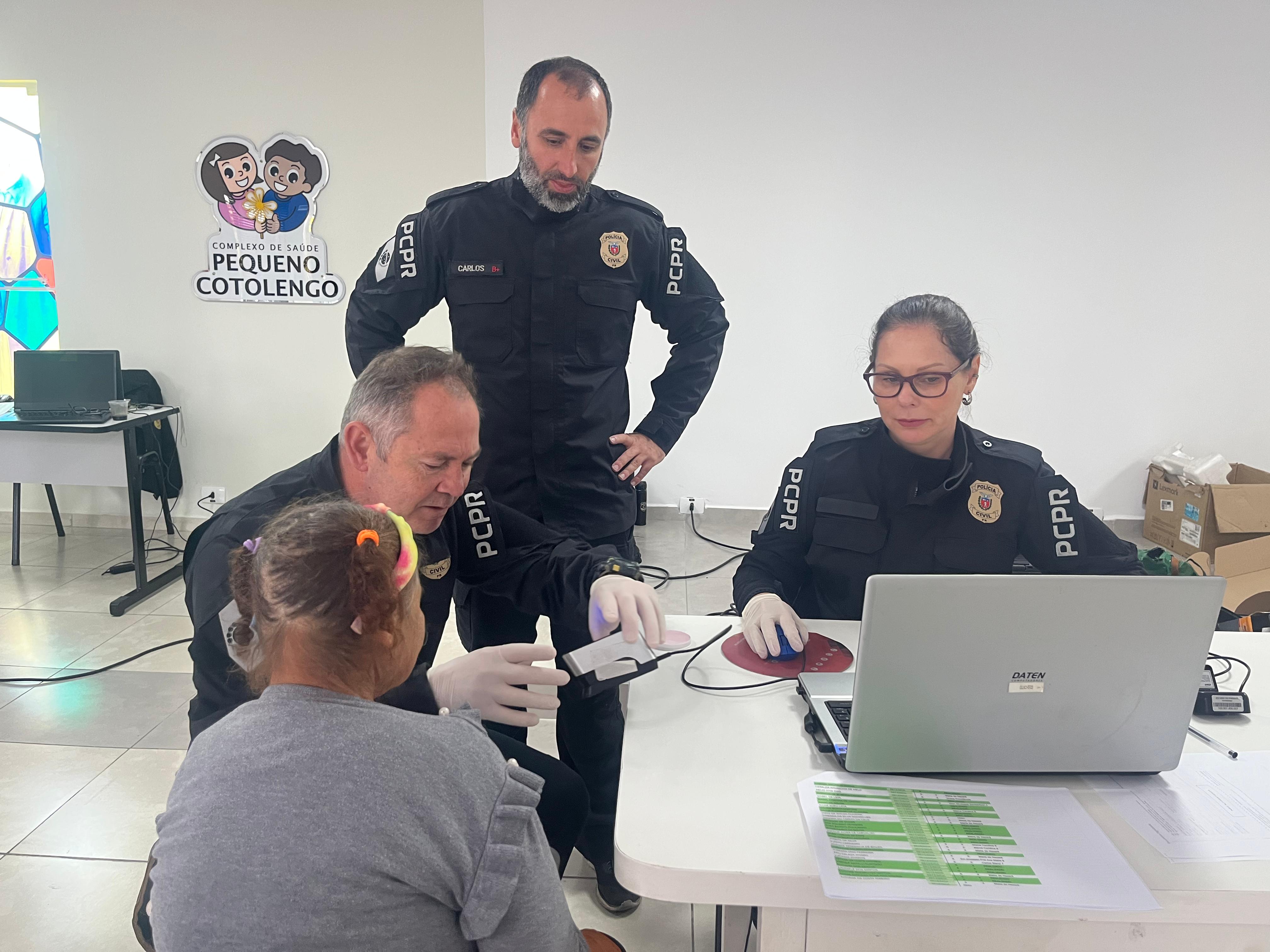 Servidores do Instituto de Identificação realizam a coleta de digitais para realização da identidade de uma mulher idosa que reside no Pequeno Cotolengo.