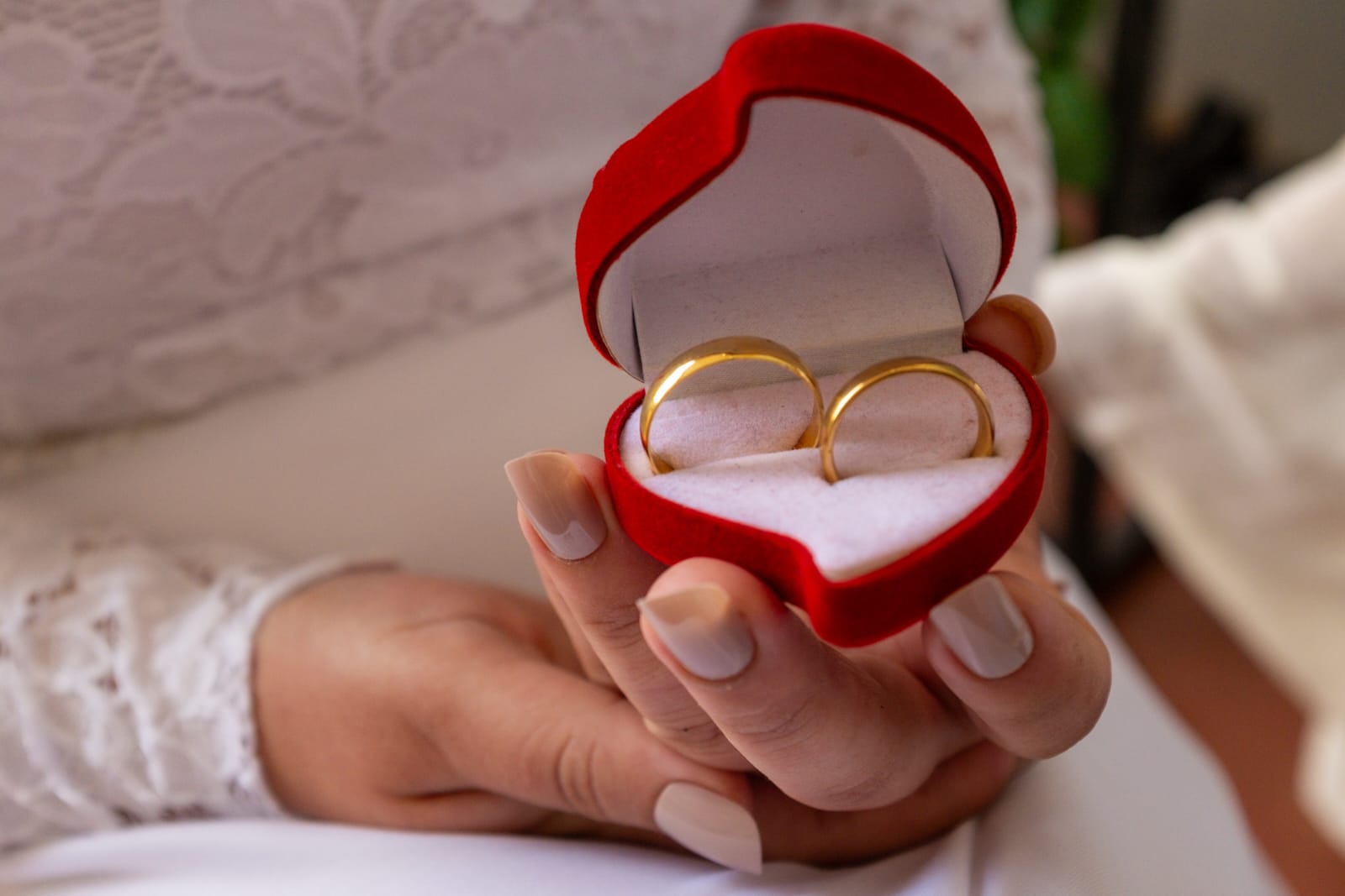 Detalhe da noiva mostrando o par de alianças para a foto.