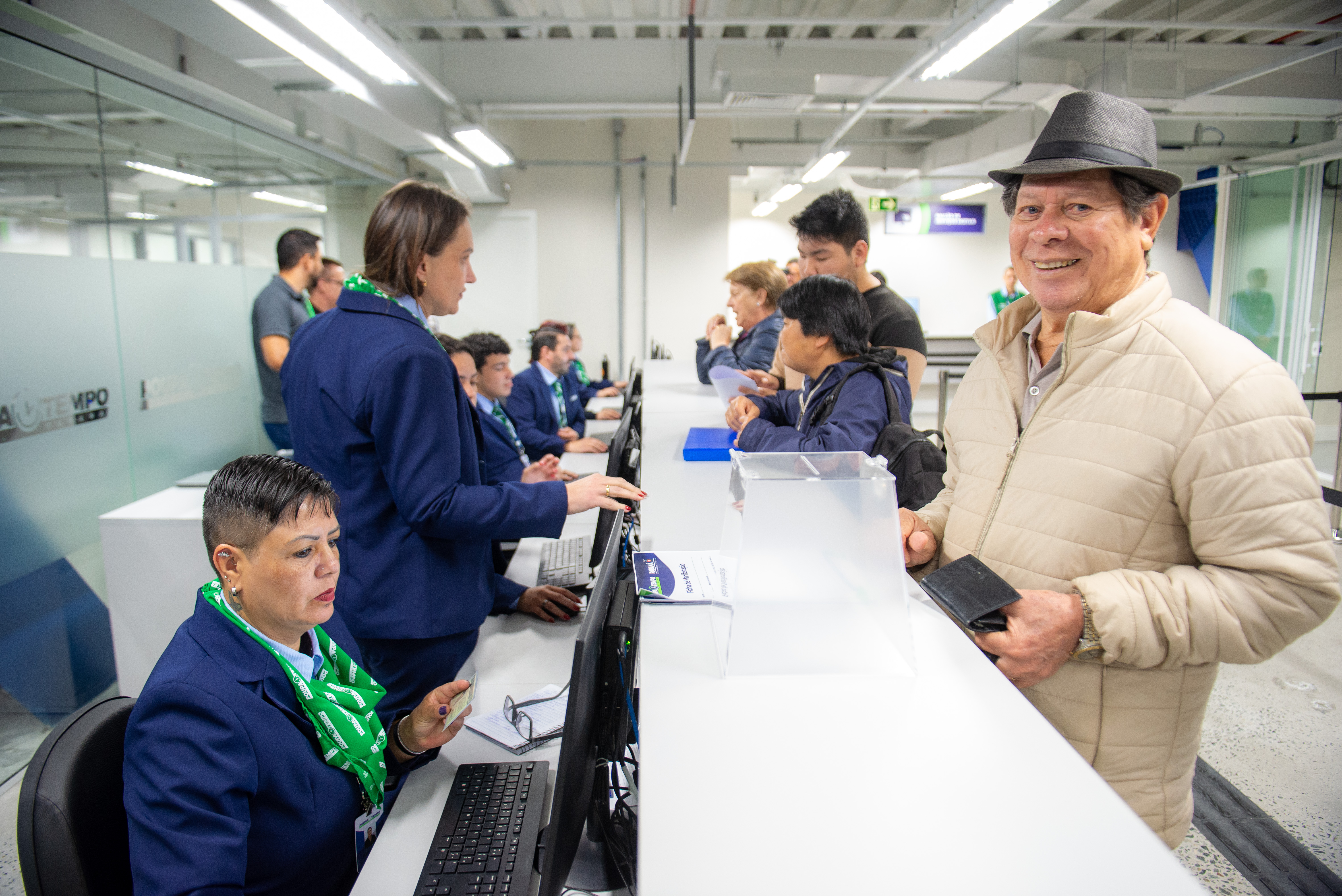 Senhor idoso de chapéu é atendido no posto do Poupa Tempo do Governo do Estado.