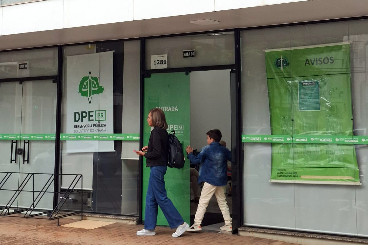 Mulher e criança vistos de longe chegam à sede da DPE-PR em Maringá para participar de Mutirão; 