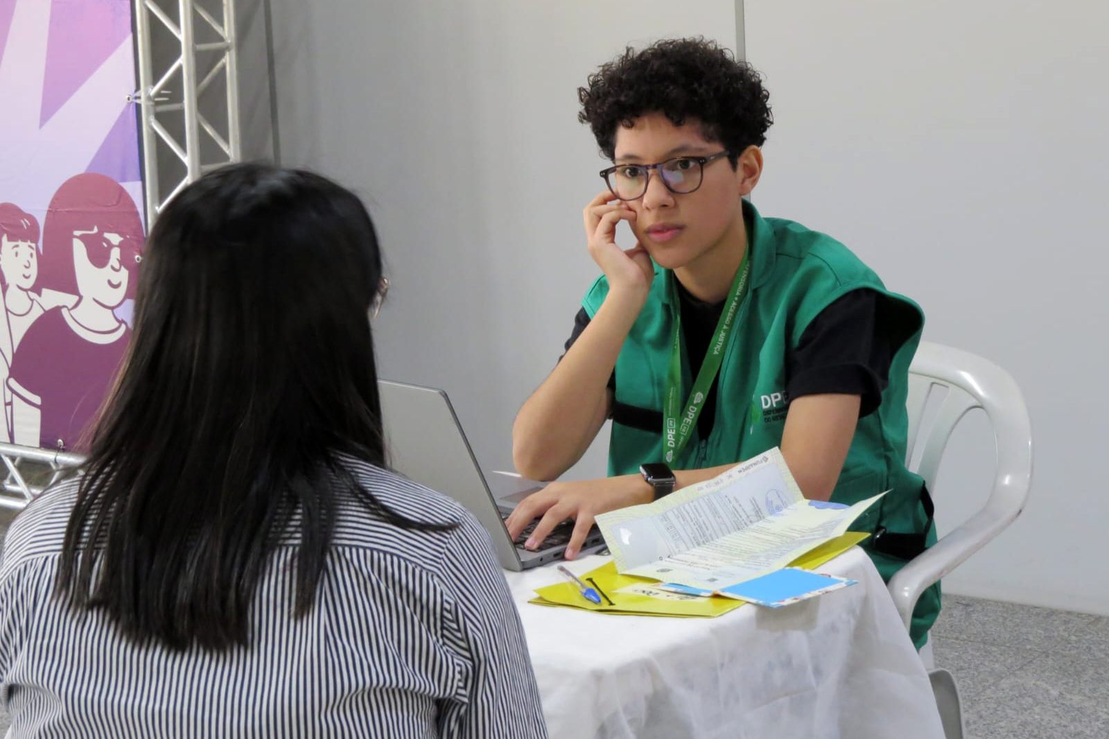 Servidora da DPE-PR realiza atendimento de uma mulher durante Mutirão em Maringá.  