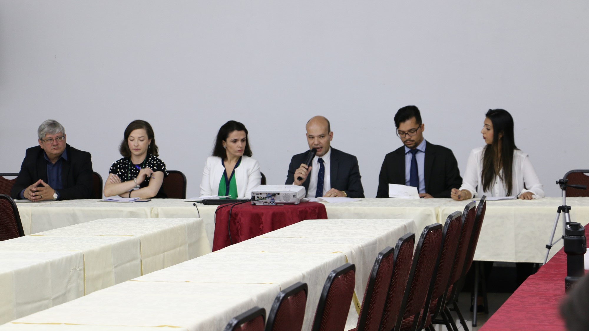 Vê-se o Dr. Eduardo Abraão, Defensor Público-Geral, sentado na mesa que compôs a abertura do evento. A sua direita está sentada a Dra. Flávia Palazzi, Diretora da EDEPAR, a Assistente Social, Gabriele Rezende, e o Ouvidor-Geral, Dr. Gerson da Sllva.
A esquerda do DPG, está sentado o presidente da ASSEDEPAR Louis Pasteur e a Psicologa Alysha Carolyna.