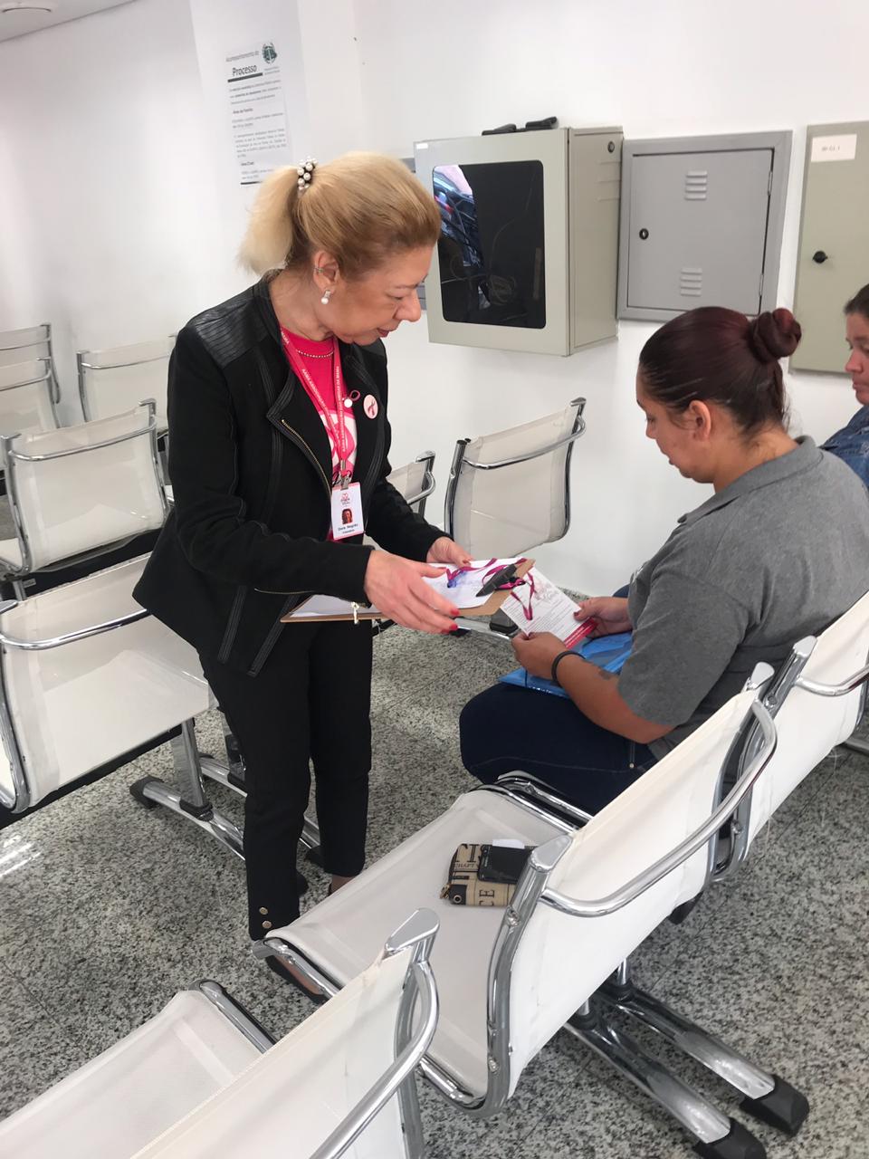 Na imagem vemos uma das voluntárias conversando com uma assistida.