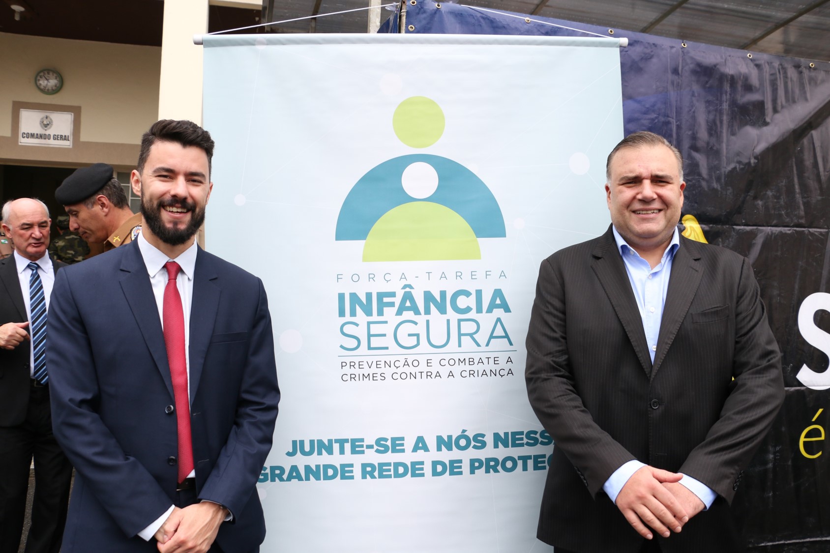Na esquerda, o subdefensor público-geral, dr. Rodolpho Mussel de Macedo. Na direita, o secretário da Justiça, Família e Trabalho, Ney Leprevost. No meio, o cartaz da força-tarefa.