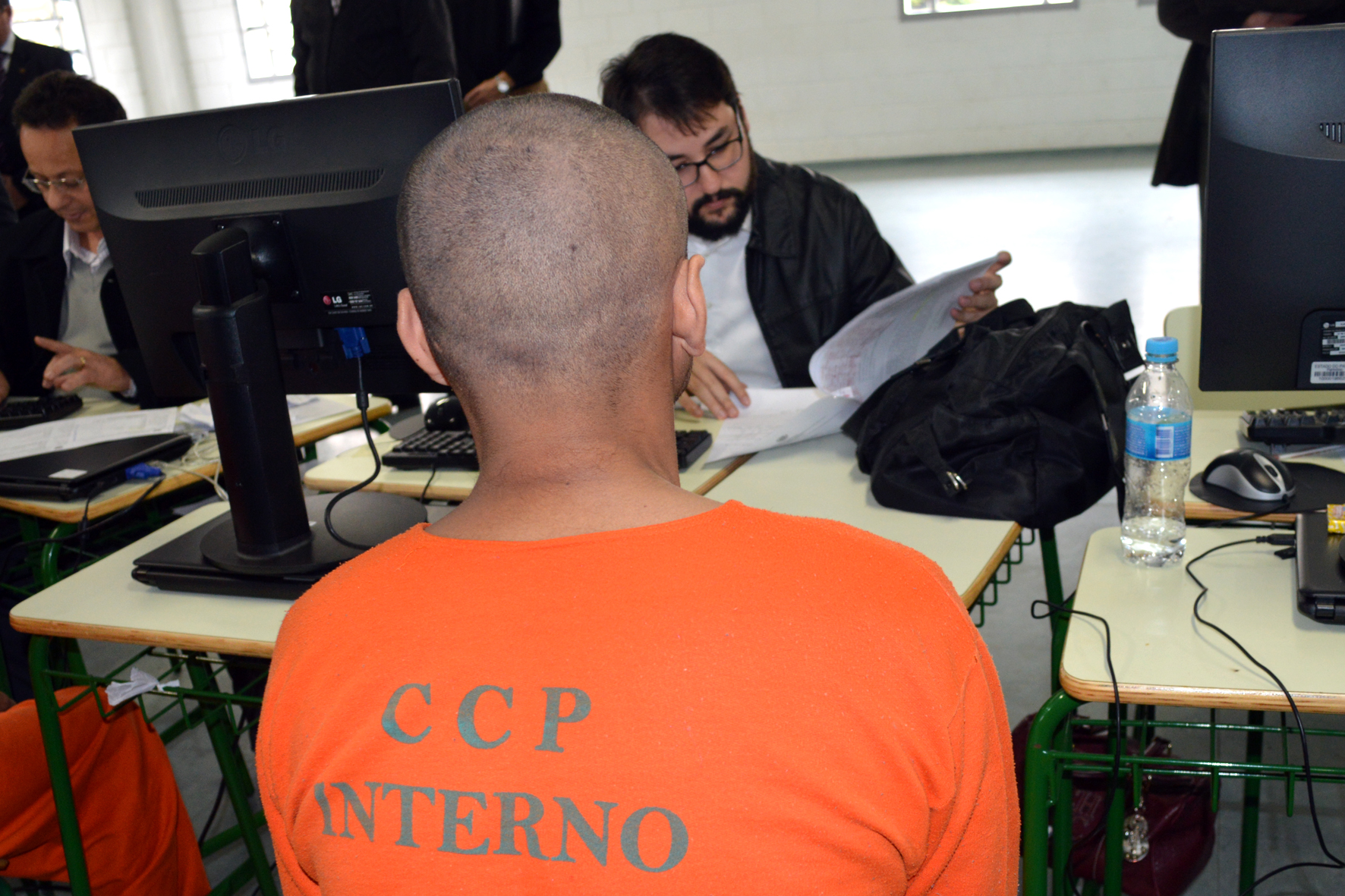 Ao fundo, o defensor público Henrique Camargo Cardoso