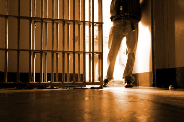 Setor de Execução Penal da DPPR provou que rapaz preso em flagrante não era o verdadeiro culpado. Descrição de imagem: na foto está aparecendo um agente penitenciário da cintura para baixo abrindo uma cela.