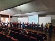 Imagem que mostra uma banda de metais formada por adolescentes se apresentando para a plateia do evento.