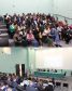 Imagem aberta mostrando o auditório todo lotado de defensores e defensoras públicas durante o evento.