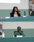 Imagem em formato de colagem, na foto de cima, está a advogada e mestranda em Direitos Humanos e Democracia pela UFPR, Nahomi Helena de Santana, palestrando. Na foto abaixo, está a presidenta do Conselho Estadual dos Direitos das Mulheres do Paraná e membra da Rede de Mulheres Negras do Paraná, a Ivanete Xavier, sorrindo enquanto palestra.
