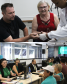 Imagem com duas fotos: acima, assistidos fazem exame de coleta de DNA para teste de maternidade; abaixo, equipe da DPE-PR em atendimentos durante o mutirão.
