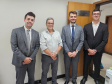Imagem que mostra a inauguração da sala da DPE-PR em Cruzeiro do Oeste. Representantes da Defensoria posam em frente à porta da sala da DPE-PR, do lado de dentro da sala.