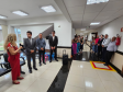 Imagem que mostra a inauguração da sala da DPE-PR em Cruzeiro do Oeste. Várias pessoas estão em pé, em um corredor e em uma pequena sala de recepção do Fórum, assistindo a solenidade.