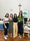 Imagem que mostra a equipe da DPE-PR que atende a população em Jandaia do Sul. São quatro mulheres: a defensora pública Maria Luiza Valverde, a assessora Isabela Caniato e as estagiárias Juliana Morais de Souza e Ana Clara de Carvalho Laurentino. As quatro estão lado a lado, abraçadas e sorriem.