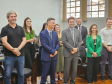 Imagem que mostra representantes da Defensoria e autoridades convidadas na inauguração da sala da DPE-PR em Jandaia. As pessoas, 4 mulheres e 5 homens, estão em pé, diante de cadeiras e todos riem.