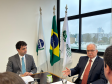 Imagem com a foto do Ministro Fachin sentado à mesa ao lado do Defensor Público-Geral, André  outras personalidades representantes das catergorias e setores da Defensoria.