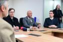 Imagem com o diretor-geral da Polícia Científica, Luiz Rodrigo Grochocki, juntamento do secretário de Segurança Pública, Hudson Leôncio Teixeira,  e do Defensor Público-Geral, Matheus Munhoz, sentados em uma mesa e se pronunciando durante a coletiva de imprensa