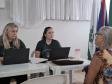 Imagem que mostra um dos atendimentos do evento. Duas pessoas da Defensoria atendem uma senhora. 