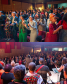 Duas imagens sobrepostas. Na de cima o público dança durante apresentação cultural no evento. Na imagem de baixo se vê os cantores e músicos da apresentação. 