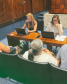 Imagem de uma foto de um atendimento presencial, duas servidoras públicas estão conferindo informações em seus notebooks enquanto três usuários da Defensoria Pública aguardam. Na parte central inferior da imagem, está o título da matéria.