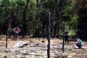 Imagem colorida horizontal em que se vê a equipe da DPE-PR verificando casa queimada na aldeia durante os conflitos com indígenas em Guaíra.  