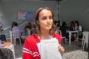 Imagem horizontal colorida em que aparece um assistido saindo com atendimento com documentos do processo iniciado junto a DPE-PR.