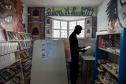 Imagem horizontal colorida em que se vê jovem na biblioteca da unidade socioeducacional.  