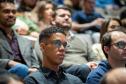 Foto em detelhe em que se vê os novos servidores sentados no auditório acompanhando discursos de posse. 