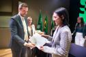 Imagem mostra nova servidora recebendo termo de posse das mãos do DPG. 