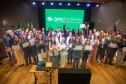 Servidores posam juntos no placo para foto ao fim da cerimônia. 