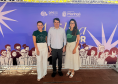 Três pessoas posam em frente a um banner do programa Agiliza da Defensoria Pública do Paraná. 