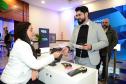 Mulher sentada apresenta serviços de tecnologia para homem com barba de terno em pé. 