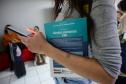 Imagem mostra o braço de uma mulher em close segurando livro jurídico para consulta antes da prova do V Concurso Público para Defensora e Defensor Público do Estado do Paraná. 