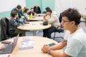 Em primeiro plano um assistido da DPE-PR recebe orientação jurídica sobre retificação de nome nos documentos.  