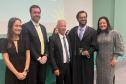 Novo defensor público empossado posa ao lado de representantes da instituição e familiares. 