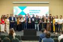 Premiados no concurso de inovação da Defensoria posam para foto no palco do evento. 