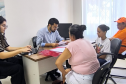 Imagem mostra um Defensor Público realizando atendimento a duas mulheres. 