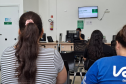 Imagem mostra duas mulher de costas aguardando na fila para recebem atendimento durante o Mutirão da Defensoria em Maringá. 