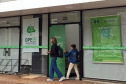 Mulher e criança vistos de longe chegam à sede da DPE-PR em Maringá para participar de Mutirão; 