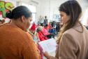 Imagem mostra Defensora Pública conversando com uma assistida durante mutirão de atendimentos da DPE-PR.