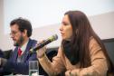 Ana Carolina Pinto fala ao microfone. Ela é Promotora de Justiça do Ministério Público do Estado do Paraná.