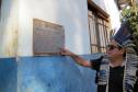Cacique mostra a placa comemorativa à instalação do telefone público na comunidade. 